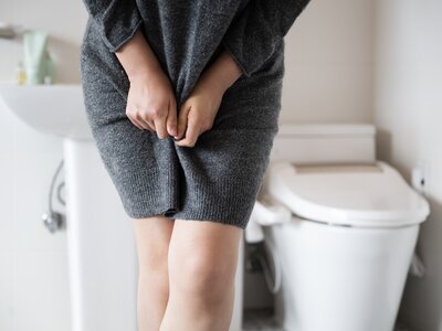Online-Pflegekurs zum Thema Inkontinenz – Hilfe für pflegende Angehörige | © PflegeBetreuer | unabhängige Pflegeberatung Frau mit Inkontinenzproblemen steht vor einer Toilette – Symbolbild für Online-Pflegekurs | © PflegeBetreuer | unabhängige Pflegeberatung